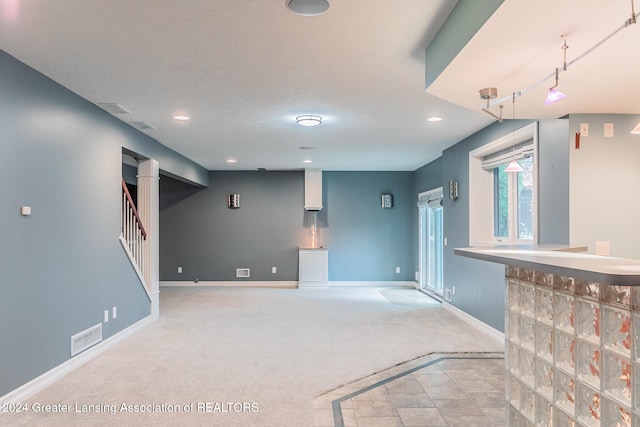 unfurnished living room featuring recessed lighting, light carpet, visible vents, baseboards, and stairway