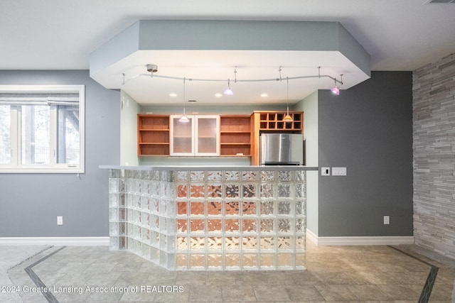 kitchen with hanging light fixtures, visible vents, baseboards, and freestanding refrigerator