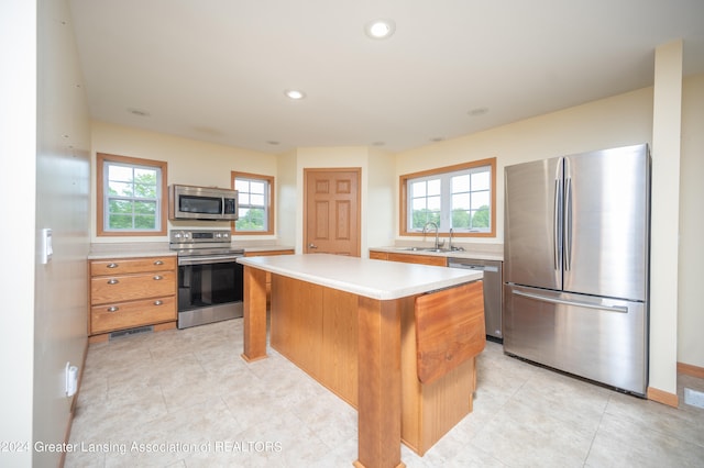 kitchen with appliances with stainless steel finishes, a center island, sink, and a wealth of natural light