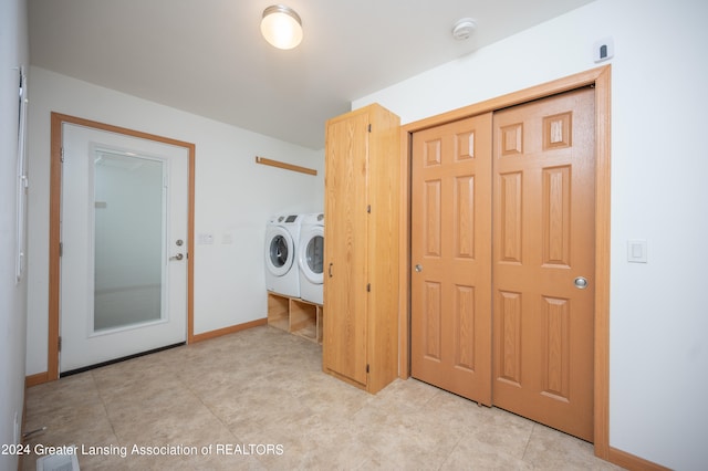 laundry room with washer and dryer and light tile patterned floors