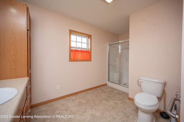 bathroom with vanity, toilet, and a shower with shower door