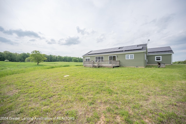 rear view of property with a deck and a yard