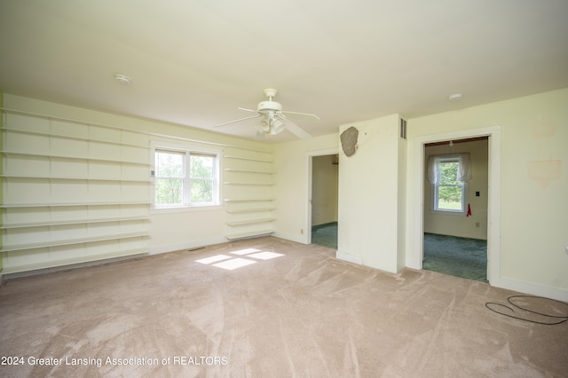 empty room featuring ceiling fan and light colored carpet