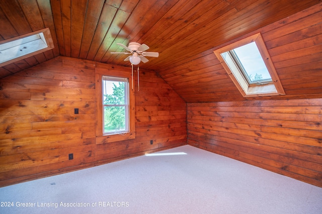 additional living space with carpet flooring, ceiling fan, wooden ceiling, vaulted ceiling, and wooden walls