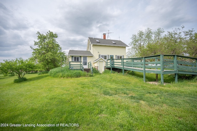 back of property featuring a yard and a deck