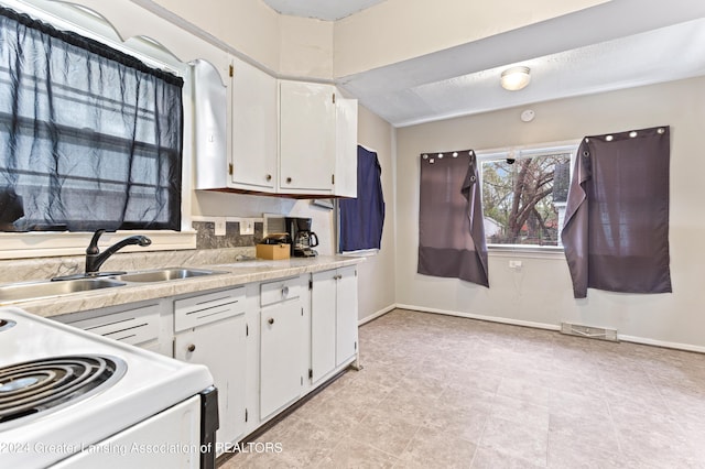 kitchen featuring white cabinets, white range, and sink