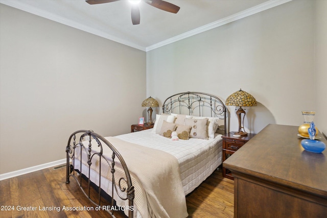 bedroom with dark hardwood / wood-style floors, ceiling fan, and crown molding