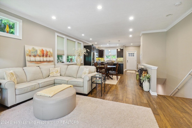 living room featuring crown molding, plenty of natural light, and dark wood-type flooring