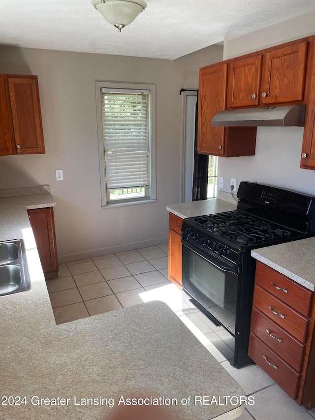 kitchen with black range with gas stovetop and light tile patterned flooring