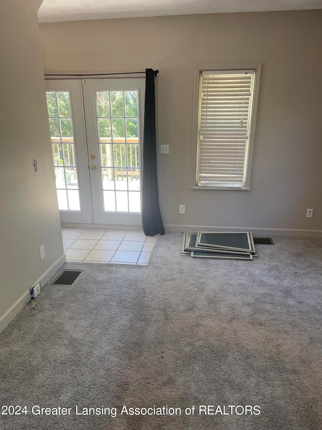 unfurnished room with french doors and light carpet