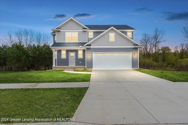 view of front of house with a garage, driveway, a shingled roof, and a front lawn