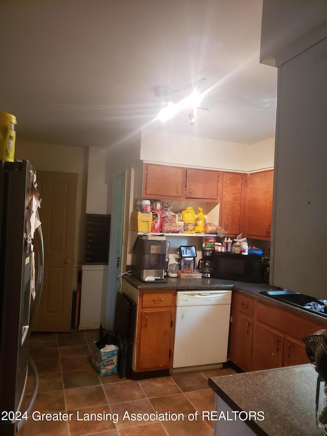 kitchen featuring white dishwasher and stainless steel fridge