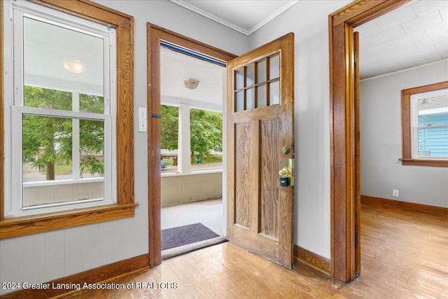 entryway with crown molding and light hardwood / wood-style flooring