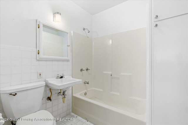 full bathroom featuring tile patterned floors, shower / bathtub combination, sink, tile walls, and toilet