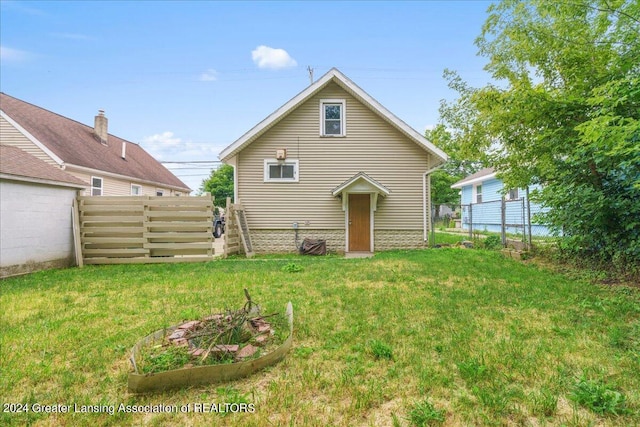 rear view of house featuring a lawn