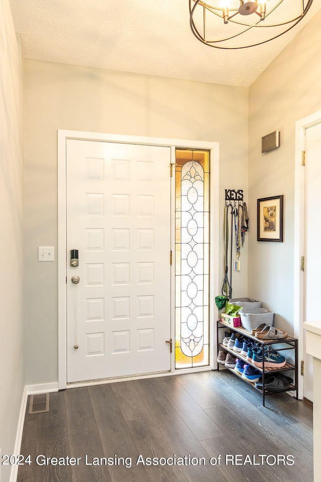 foyer featuring a textured ceiling and dark hardwood / wood-style floors