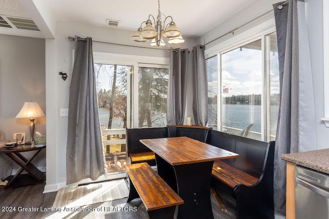 411 N Scott Dr, Farwell, MI 48622 - dining room featuring a chandelier, plenty of natural light, wood finished floors, and a water view