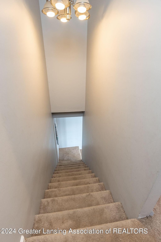 411 N Scott Dr, Farwell, MI 48622 - stairs featuring a chandelier and carpet flooring
