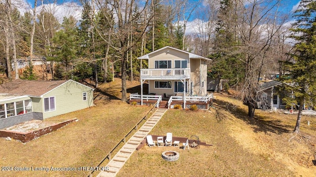 411 N Scott Dr, Farwell, MI 48622 - view of front of house with a deck, a balcony, a fire pit, stairs, and a front lawn