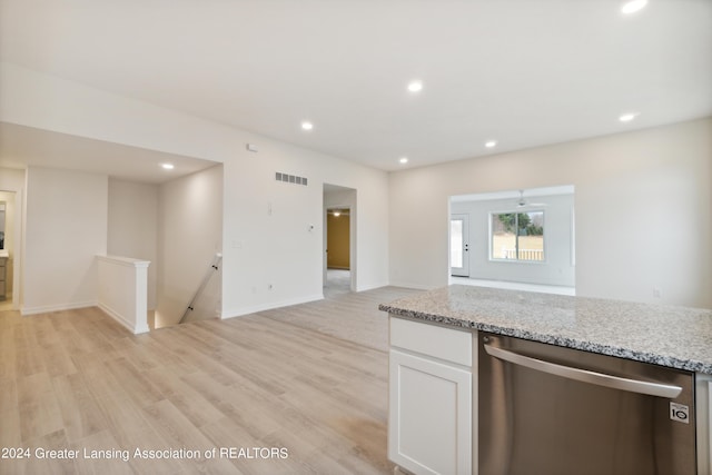 302 Vansickle Dr Unit 35, Charlotte, MI 48813 - kitchen with stainless steel dishwasher, open floor plan, light wood-style floors, white cabinetry, and light stone counters
