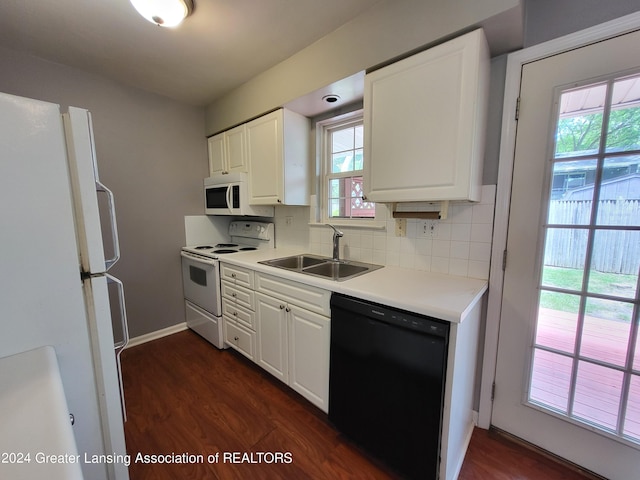 kitchen featuring white appliances, sink, dark hardwood / wood-style floors, tasteful backsplash, and white cabinetry