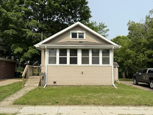 1555 Roosevelt Ave, Lansing, MI 48915 - bungalow featuring a front yard and a shingled roof