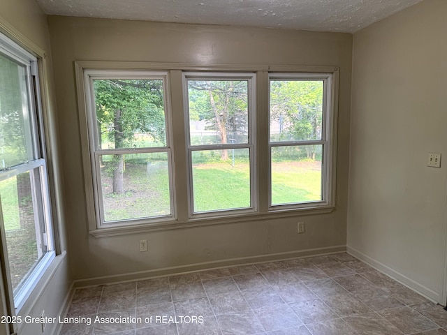 1555 Roosevelt Ave, Lansing, MI 48915 - spare room featuring baseboards and a textured ceiling