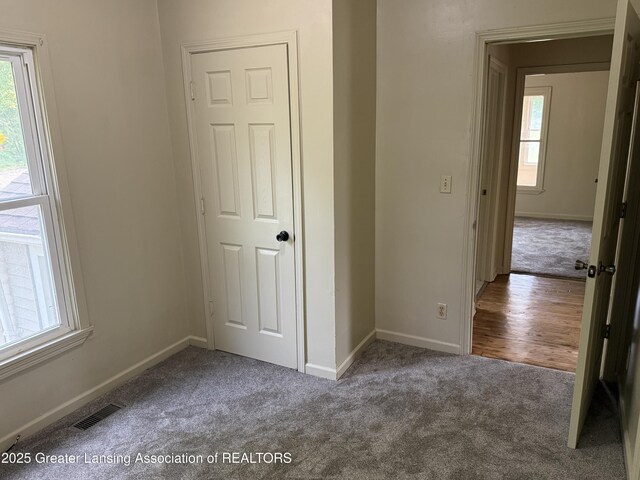 1555 Roosevelt Ave, Lansing, MI 48915 - unfurnished bedroom with carpet and multiple windows