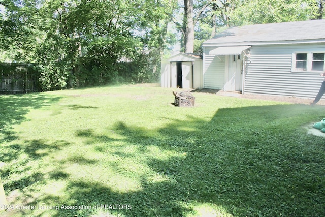 view of yard featuring a fire pit and a shed