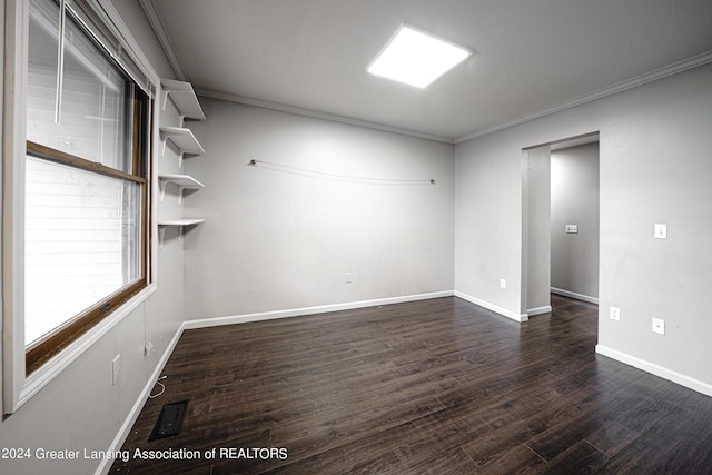 unfurnished room featuring dark wood-type flooring and crown molding