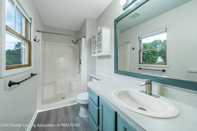 bathroom with a shower, a wealth of natural light, and hardwood / wood-style flooring