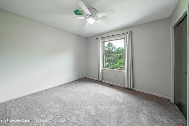 unfurnished room with ceiling fan and carpet flooring