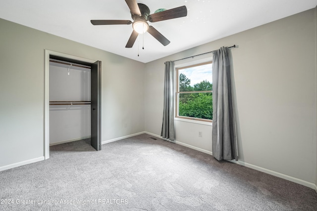 unfurnished bedroom featuring ceiling fan, light colored carpet, and a closet