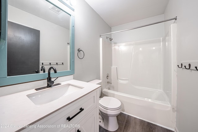 full bathroom with vanity, washtub / shower combination, toilet, and wood-type flooring