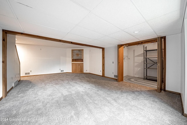 basement featuring a paneled ceiling and carpet floors