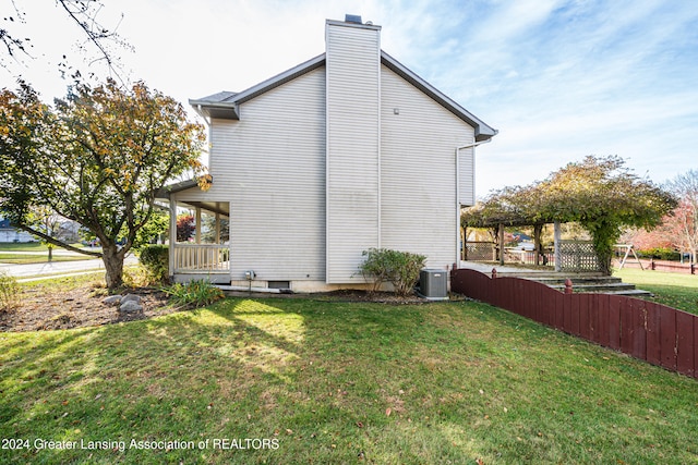 view of home's exterior featuring cooling unit and a lawn