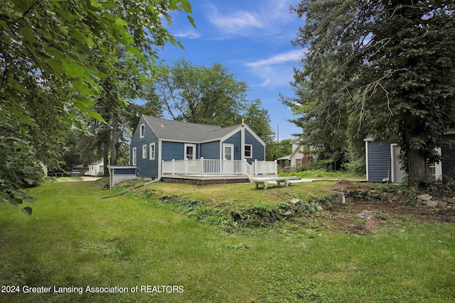 rear view of house with a deck and a lawn