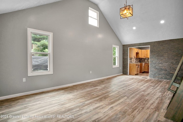 unfurnished living room featuring hardwood / wood-style floors and high vaulted ceiling