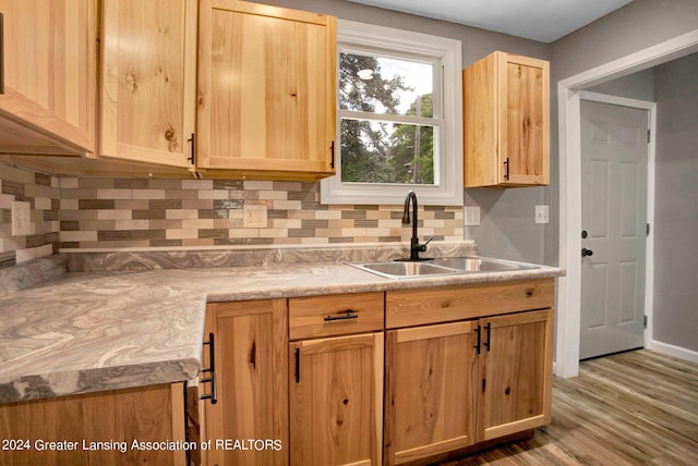 kitchen with sink, tasteful backsplash, and hardwood / wood-style floors