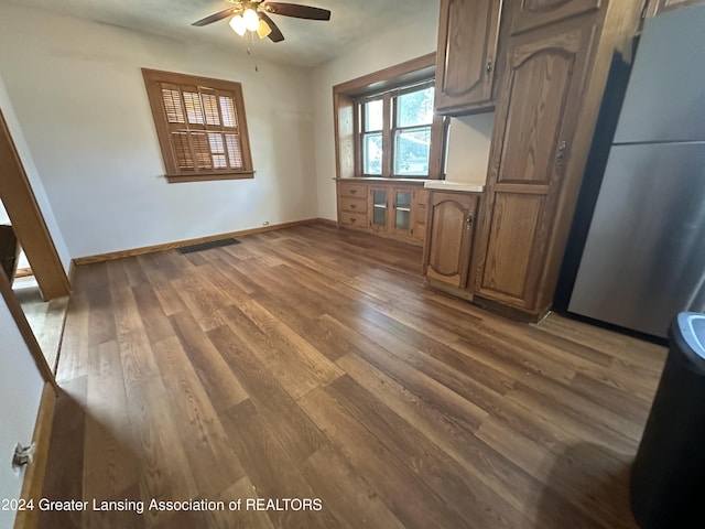 interior space with ceiling fan, dark hardwood / wood-style flooring, and stainless steel refrigerator