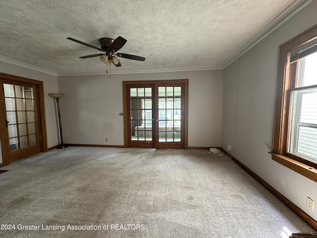 carpeted empty room featuring ceiling fan, french doors, a textured ceiling, and ornamental molding