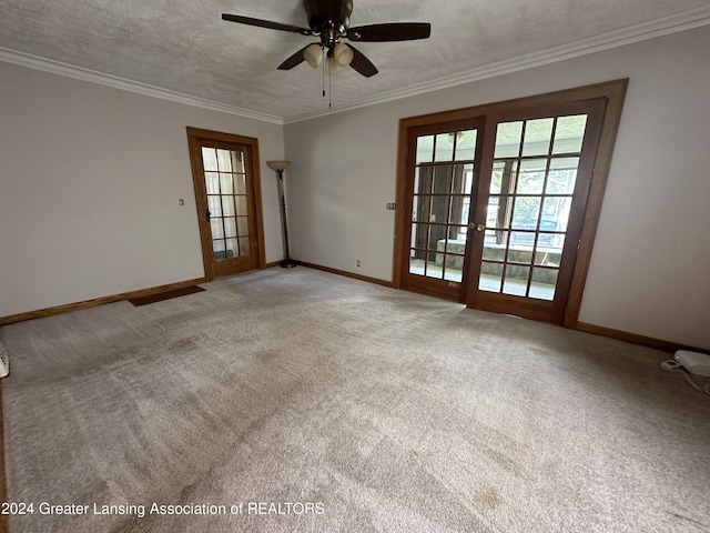 carpeted spare room featuring ceiling fan, ornamental molding, and a textured ceiling