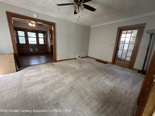 carpeted spare room with ceiling fan, a textured ceiling, and ornamental molding