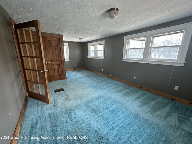 unfurnished bedroom featuring a textured ceiling and carpet floors