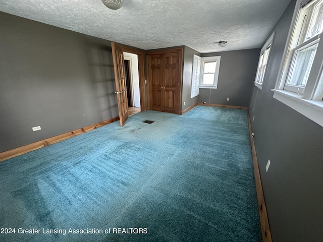 unfurnished bedroom featuring carpet flooring and a textured ceiling