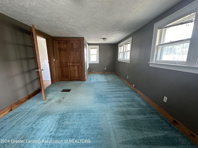 unfurnished bedroom with carpet floors and a textured ceiling