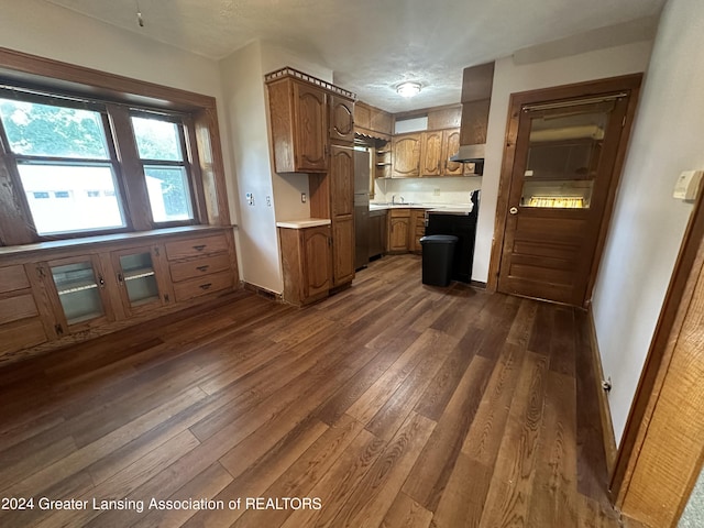 kitchen with stainless steel refrigerator, sink, and dark wood-type flooring