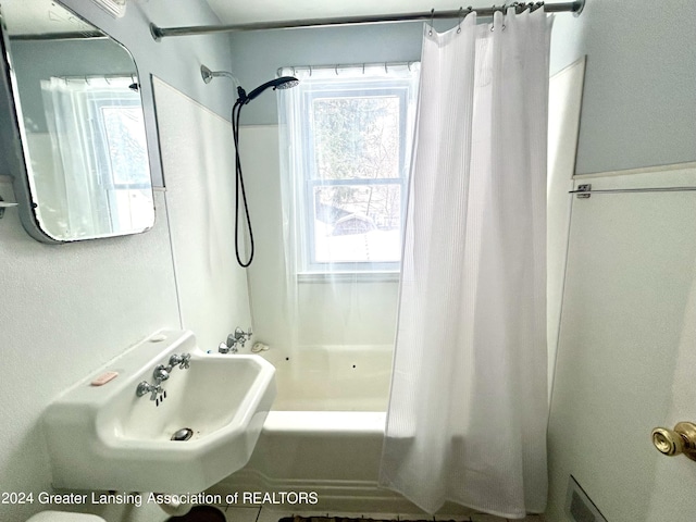 full bathroom with visible vents, shower / tub combo with curtain, and a sink