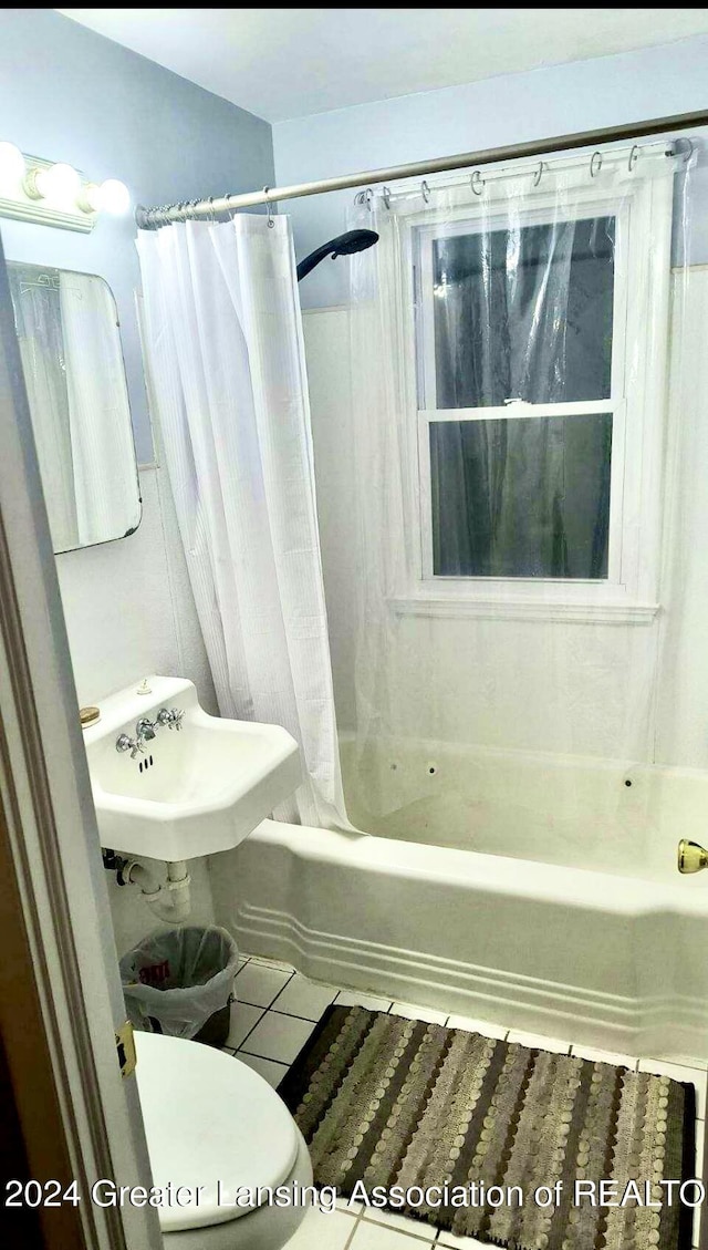 full bath featuring a sink, shower / bathtub combination with curtain, toilet, and tile patterned flooring