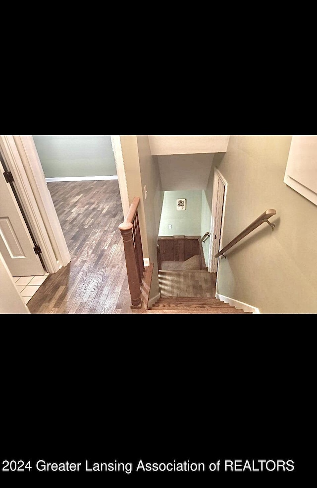 stairway featuring wood finished floors and baseboards